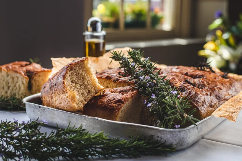 A tray of focaccia fresh from the oven at Ennios, scattered with rosemary and sea salt